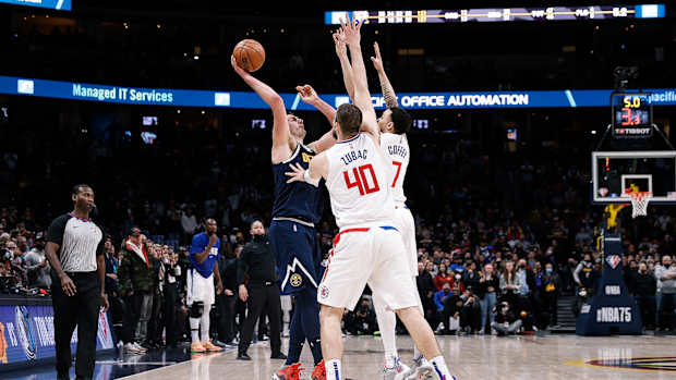 Nikola Jokic throws a pass over two defenders